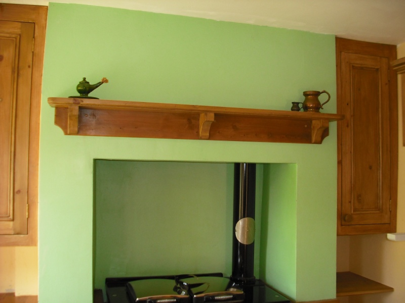 bespoke antique pine wall units in alcove and over-cooker shelf